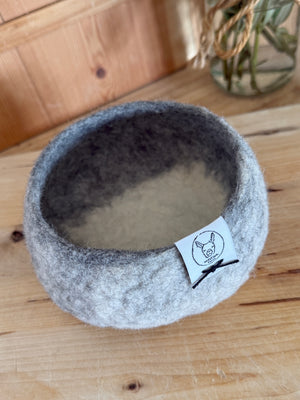 Alpaca fleece grey and white felted small bowl with plant in background.